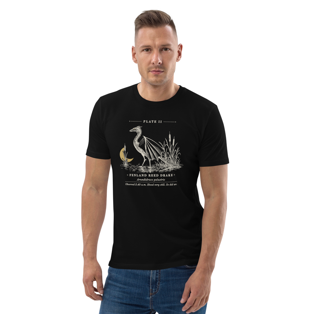 Model wearing the Fenland Reed Drake tee in Black, engraved winged reed drake wading in the reeds at centre chest