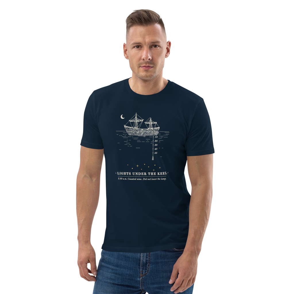 Model wearing the Lights Under the Keel tee in French Navy, the ship, lead line and nine gold lights at centre chest