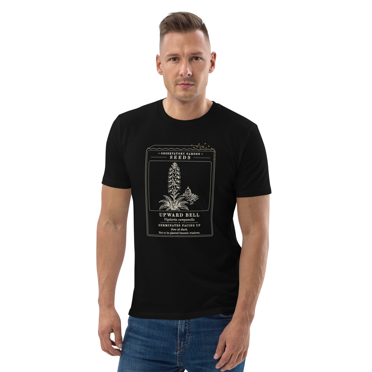 Model wearing the Germinates Facing Up tee in Black, the seed packet and gold seeds at centre chest